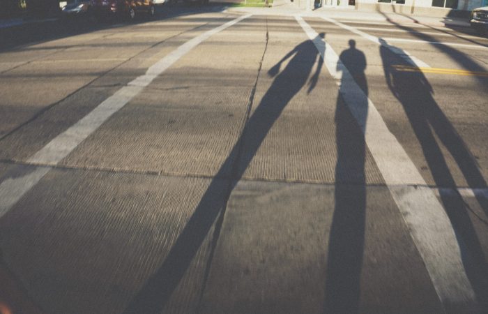 Shadow of three people walking on the street