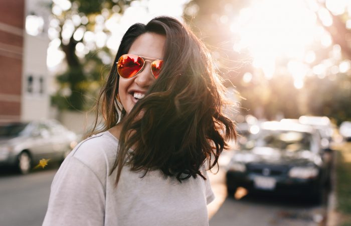 black-haired woman wearing red sunglasses smiling