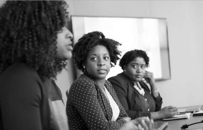 Black women talking at a desk