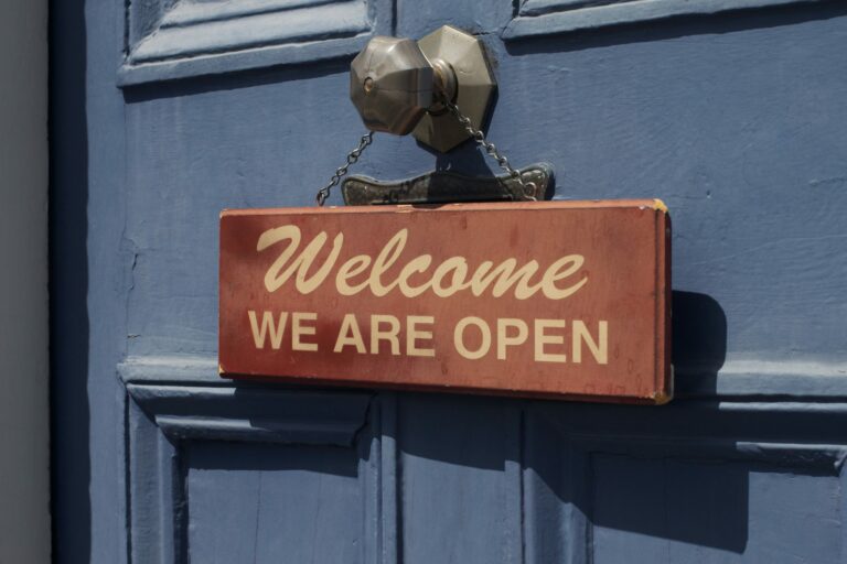 Welcome we are open sign hanging on a door handle