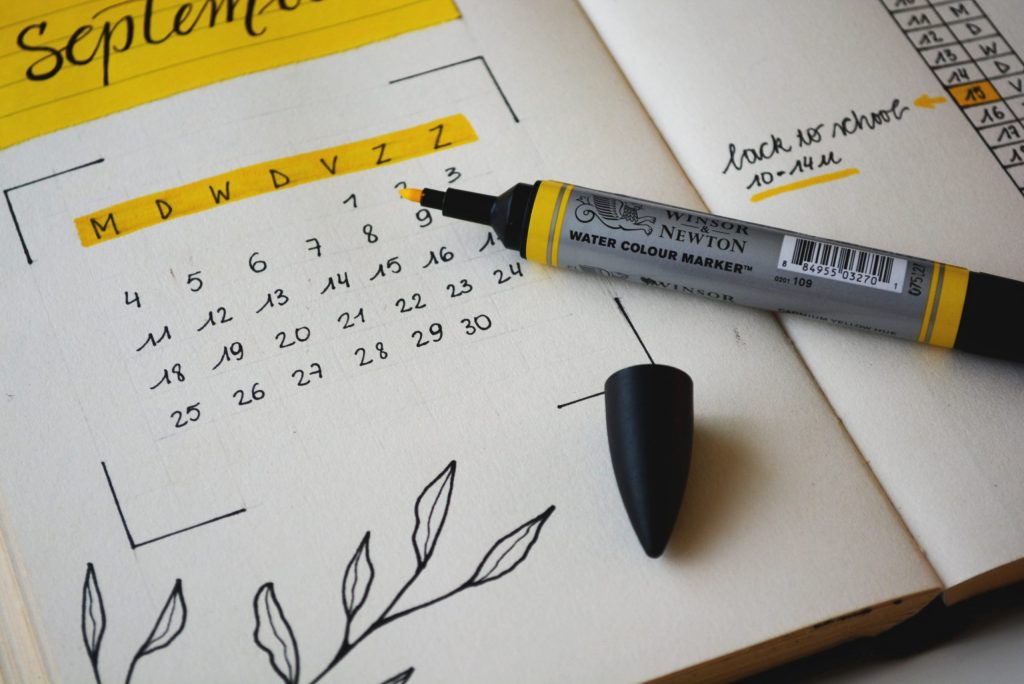 handwritten planner with weekdays highlighted in yellow
