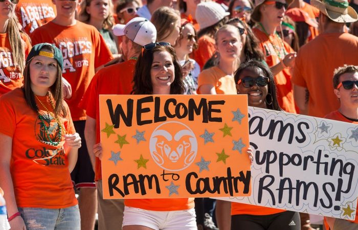 students in orange holding Rams Country posters