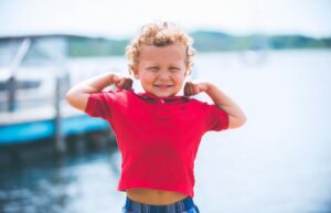little boy in red shirt flexing