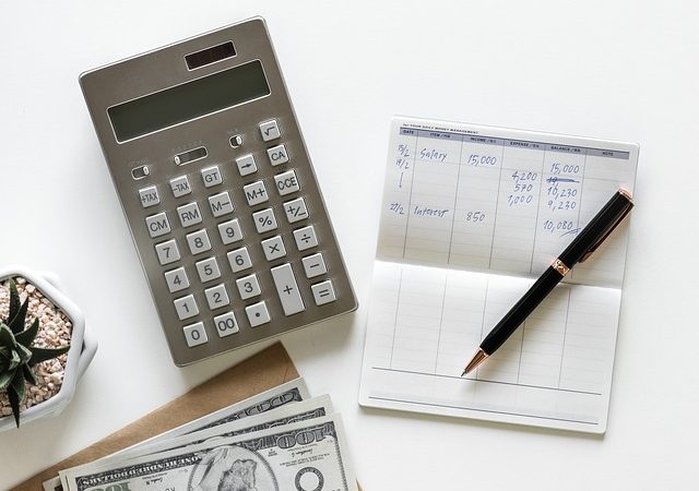 calculator, pen, checkbook, and money
