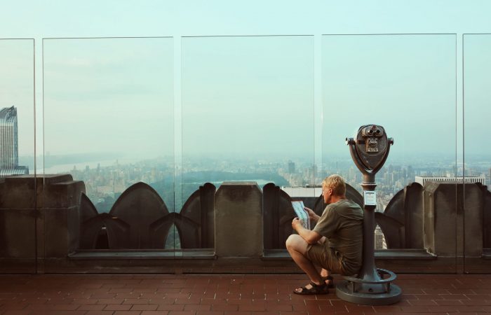 A man sitting on skyscraper binoculars