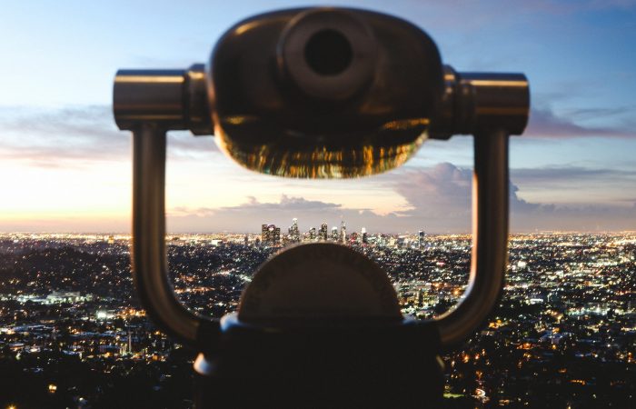 binoculars looking over city at sunrise