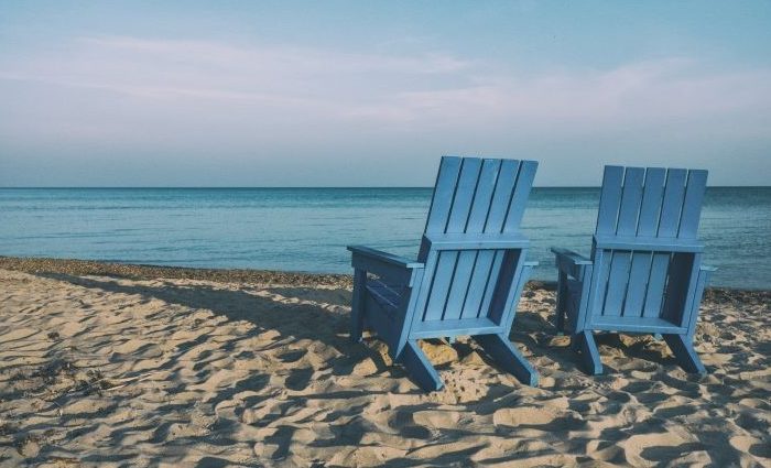 two blue beach chairs on a beach